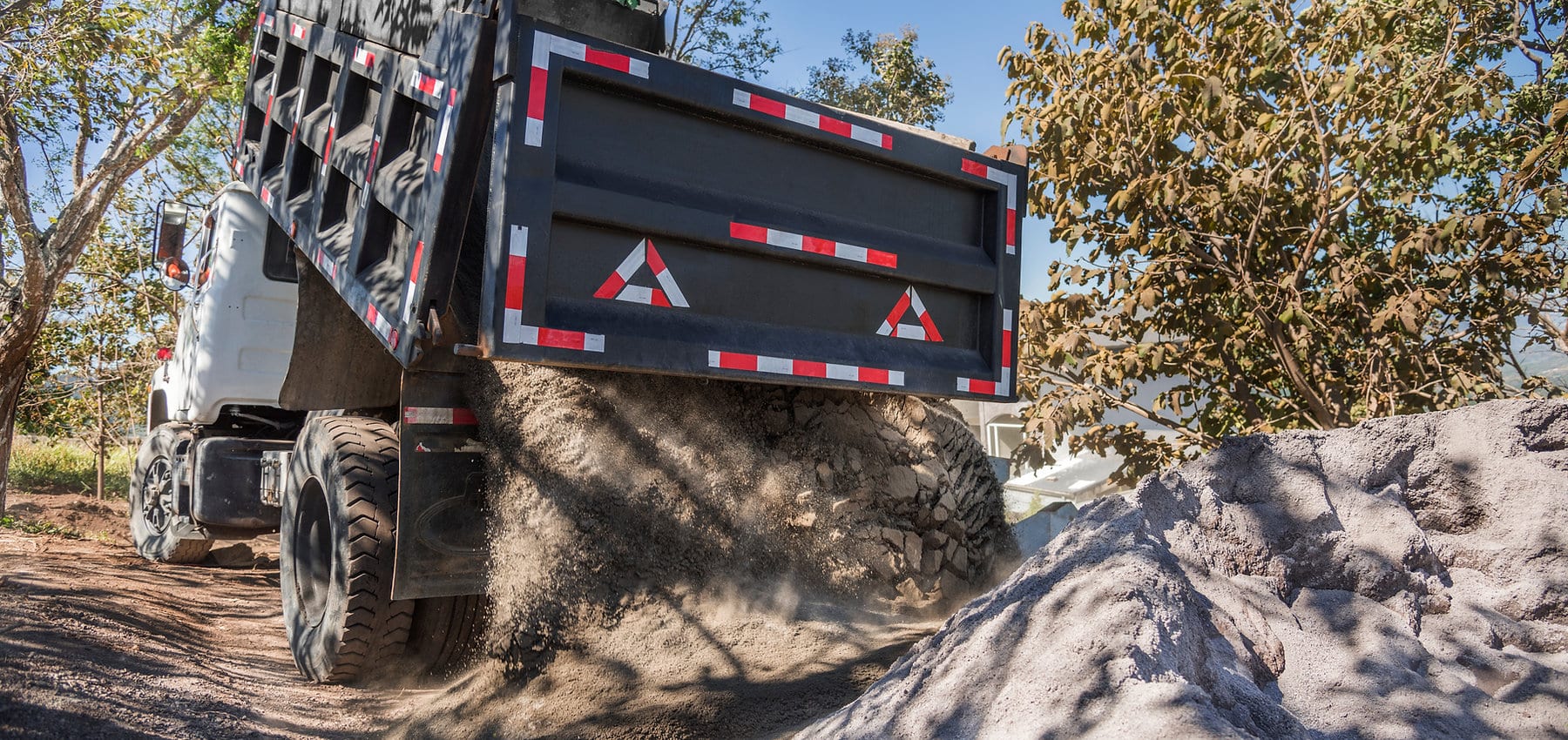 Landscape contractor dumping sand for a yard installation project in Salt Lake County